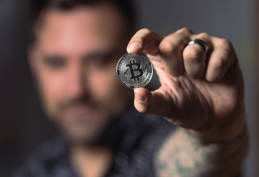 man holding a bit coin